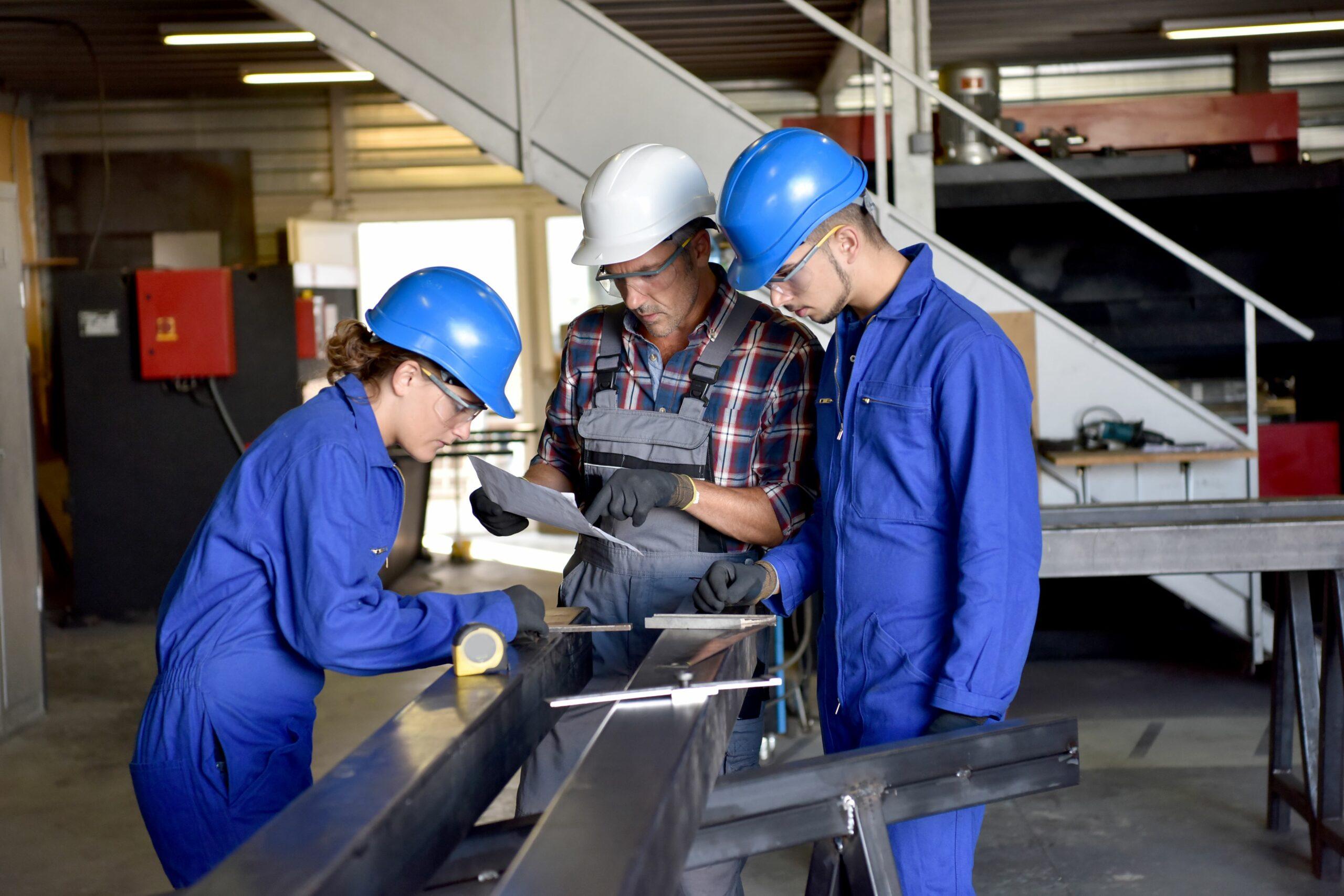 Employees participating in a manufacturing apprenticeship in metalwork.